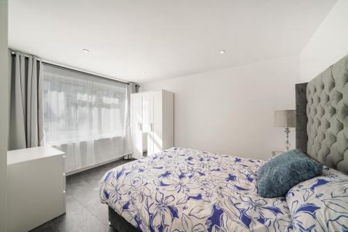 a bedroom with a bed and a large window at Modern Flat near Wembley stadium in The Hyde