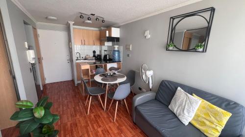 a living room with a couch and a table at Departamentos Alpro Cavancha in Iquique
