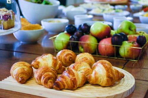 a table with croissants and apples and other foods at Hotel Świt in Kraków