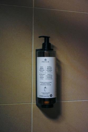 a bottle of soap is hanging on a wall at Hotel Świt in Kraków