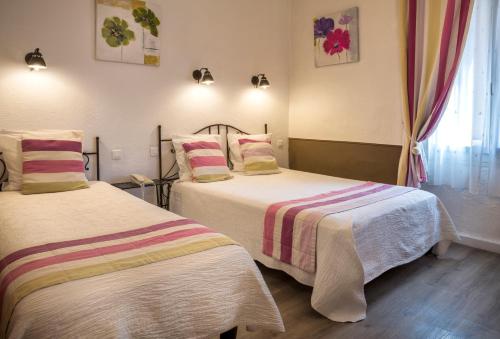 a bedroom with two beds and a window at Hotel Toppin in Cavaillon