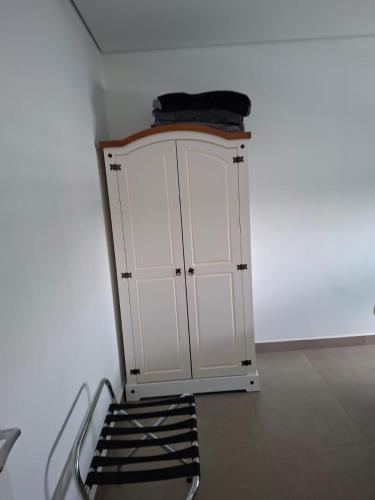 a white cabinet in the corner of a room at Residencial Miró apartamento 53 centro in Foz do Iguaçu