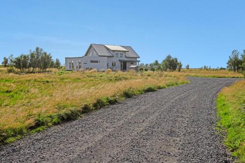 a house on a hill with a dirt road at Myri - Studio Lodge in Selfoss