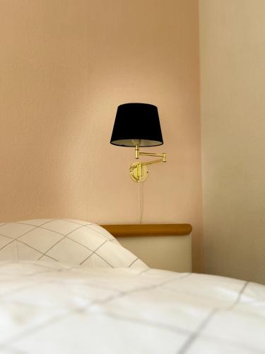 a bed with a black lamp next to a wall at AH Carinthia Mallnitz - Carinthia Appartements in Mallnitz