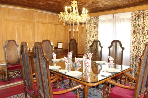 a dining room with a table and a chandelier at New York Houseboat in Srinagar