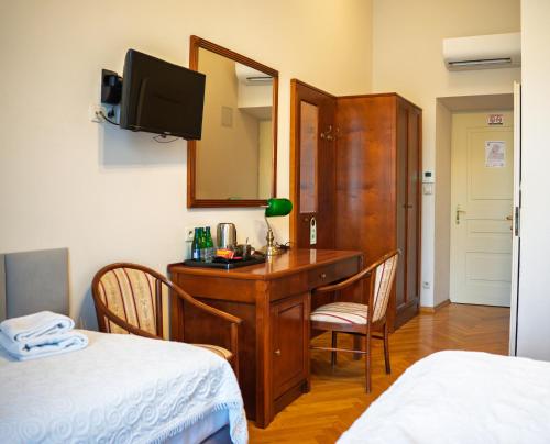 a room with a desk with chairs and a mirror at Hotel Polonia in Kraków
