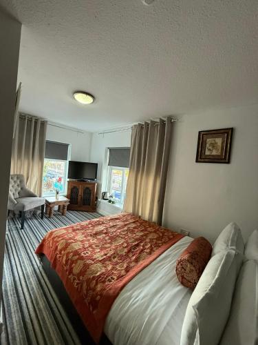 a bedroom with a large bed with a red blanket at Sids restaurant and bar with rooms in Cardiff