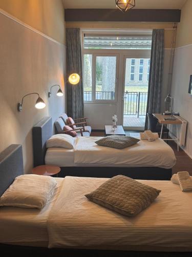 a hotel room with two beds and a window at Hotel restaurant de Pionier in Marknesse