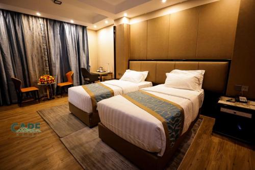 a hotel room with two beds and a table at Cape Hotel in Addis Ababa