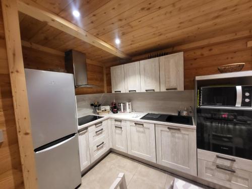 a kitchen with white appliances and wooden walls at Bel appartement cosy au calme avec wifi et vue sur la montagne in Montgenèvre