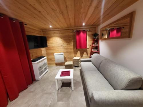 a living room with a couch and a table at Bel appartement cosy au calme avec wifi et vue sur la montagne in Montgenèvre