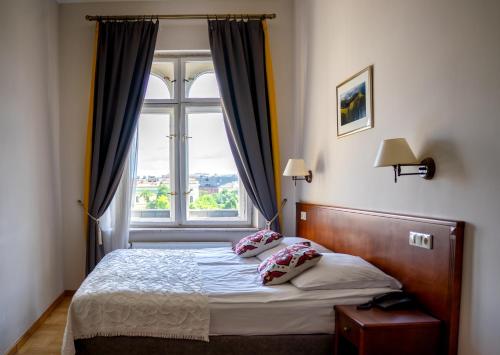 a bedroom with a bed with a large window at Hotel Polonia in Kraków