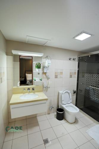 a bathroom with a sink and a toilet and a shower at Cape Hotel in Addis Ababa