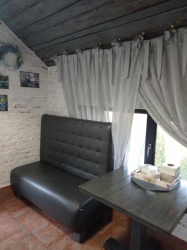 a black bench sitting in front of a table and a window at Veranda Grill in Sumy