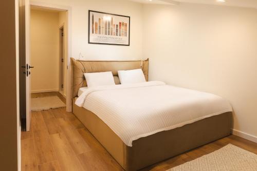 a bed with white sheets and pillows in a room at Kala Collection-Timber in Gudauri