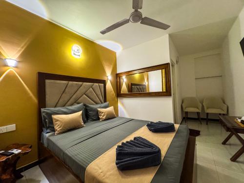 a bedroom with a large bed with a ceiling fan at Sky Garden Kandy in Kandy