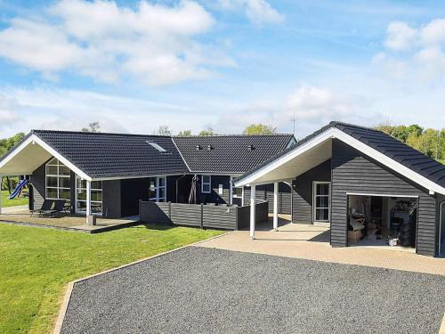 a house with a black roof and a yard at Luxury Spa Retreat in Hurup - By Traum Ferienwohnungen in Hadsund