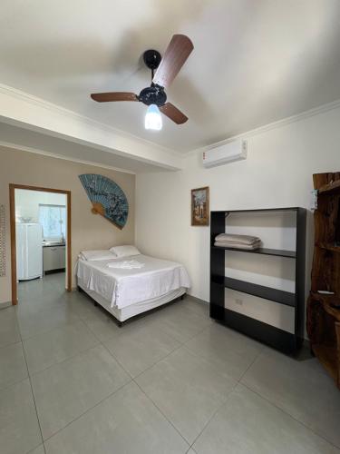 a bedroom with a bed and a ceiling fan at Chalé do Gaúcho in Ubatuba
