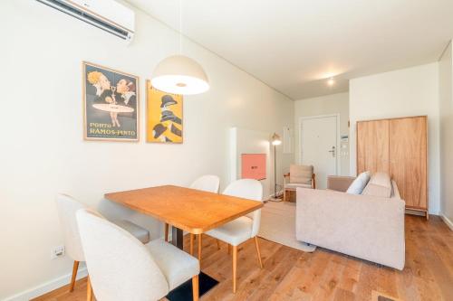 Un comedor con una mesa de madera y sillas blancas. en GuestReady - Elias Garcia Apartments, en Lisboa