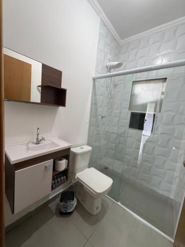 a bathroom with a shower and a toilet and a sink at Chalé do Gaúcho in Ubatuba