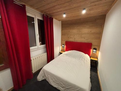 a small bedroom with a bed and red curtains at 3 pièces, 2 chambres, balcon et parking, pour 6 personnes - FR-1-263-89 in Valloire