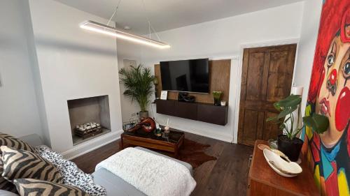 a living room with a couch and a flat screen tv at DERBY in Derby