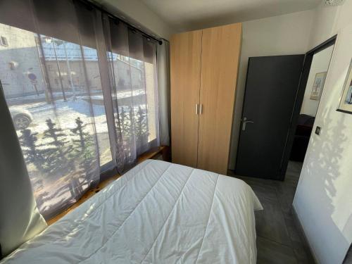 a bedroom with a bed and a large window at Charmant T2 pour 4 pers avec Sauna, WiFi et Parking privé - FR-1-263-88 in Valloire