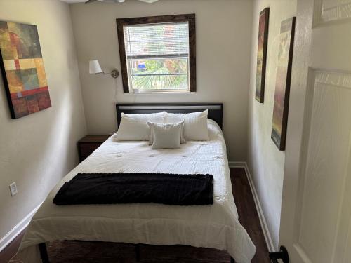 a bedroom with a bed with white sheets and a window at Harmons Landing in Hawthorne