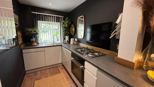 a kitchen with black walls and a stove top oven at DERBY in Derby
