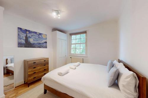 a bedroom with a large white bed and a window at Spacious 3BDR-Steps To Kings Cross Tube in London