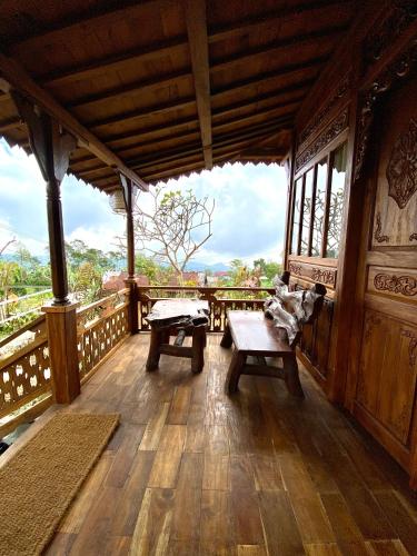 a wooden porch with two benches and a table at Langit Wanagiri in Gitgit