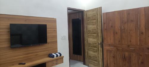 a living room with a television and wooden cabinets at JD Farm and Resorts in Rāi