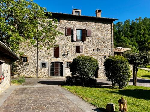 a large stone building with a gate in a yard at Borgo La Ferriera - Celleno Viterbo con Piscina in Celleno