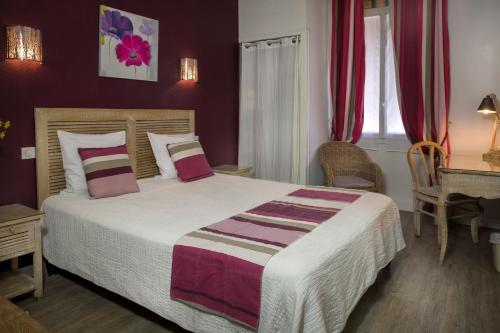 a bedroom with a large bed with red walls at Hotel Toppin in Cavaillon