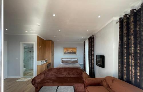 a living room with a couch and a bed at Vila Nikollaj in Kamëz