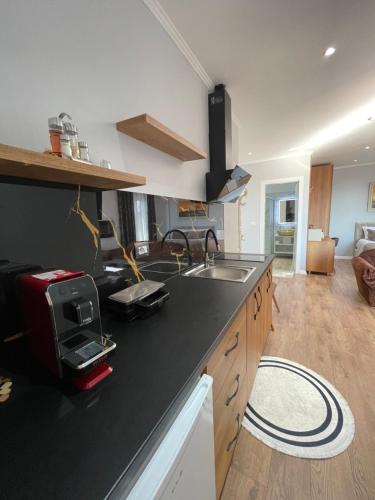 a kitchen with a black counter top and a sink at Vila Nikollaj in Kamëz