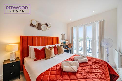 a bedroom with a large bed with a red bedspread at Brand New Premium Serviced Apartments, Free Parking, High-Speed WiFi By Redwood Stays in Cove