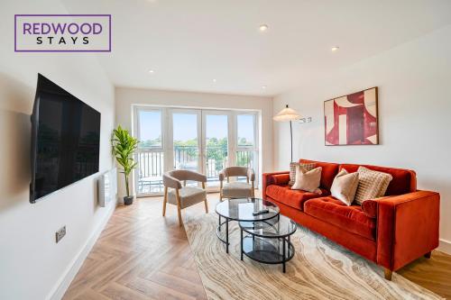 a living room with a red couch and a table at Brand New Premium Serviced Apartments, Free Parking, High-Speed WiFi By Redwood Stays in Cove