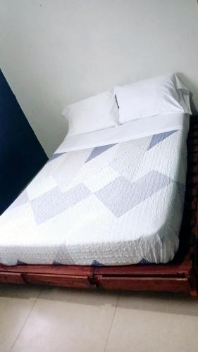a bed with white sheets and pillows on it at La casa de Issa in Alto Boquete