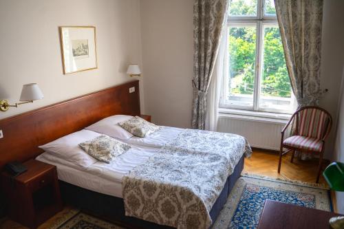 a bedroom with a bed and a large window at Hotel Polonia in Kraków