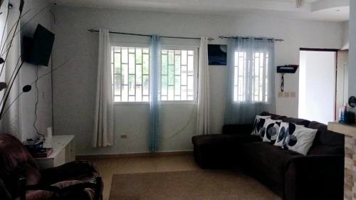a living room with a couch and two windows at La casa de Issa in Alto Boquete