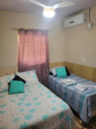 a bedroom with two beds and a window at Sossego Meu in Soure