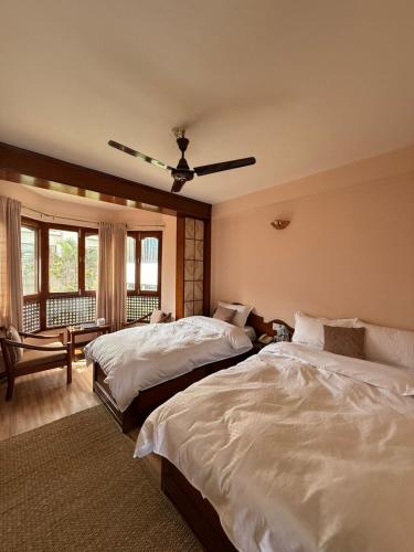 a bedroom with two beds and a ceiling fan at Laavanya Inn in Pokhara