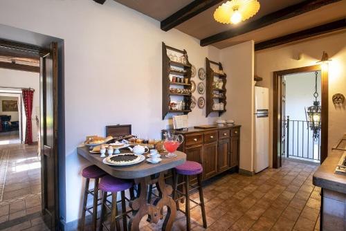 a kitchen with a table and stools in a room at Borgo La Ferriera - Celleno Viterbo con Piscina in Celleno