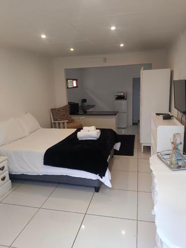 a bedroom with a bed and a living room at Artisan Guest House in Burgersdorp