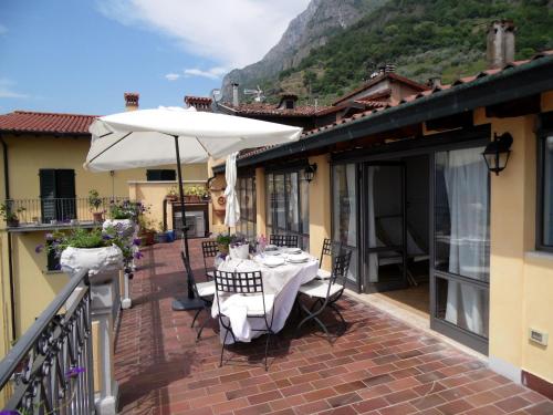 a patio with a table and an umbrella on a balcony at Apartment in Vello by Lake Iseo Beach in Marone