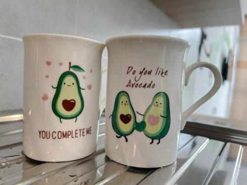 two coffee mugs with fruit on them sitting on a counter at Spacious 2BR 2BA at d Millenia in Kuching
