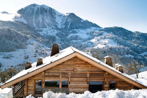 マニグードにあるLodge Les Murailles Luxury Unique Alpin Chalet Manigod La Clusazの雪山の丸太小屋