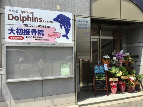 a store with a sign in a window with flowers at Tabist Sparkling Dolphins Inn Kyoto in Kyoto