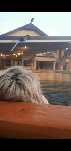a woman laying on the edge of a boat in the water at La Cheile Plaiului 